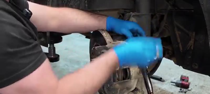 Undoing the 13mm caliper slider bolts with a spanner on the Trafic front brake