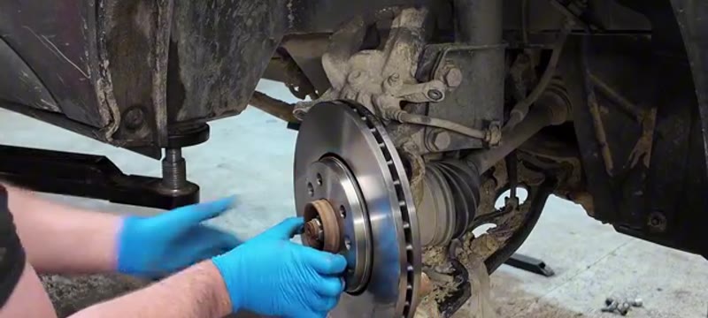 Lining up the new brake disc and retaining screws on the cleaned Trafic hub