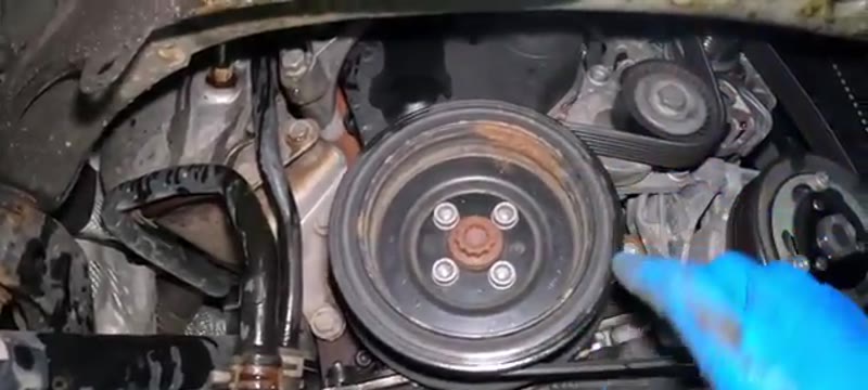 Lower crank pulley and auxiliary belt seen through the Superb wheel arch