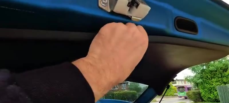 Removing the boot trim panel from the Suzuki Vitara tailgate by releasing the push clips