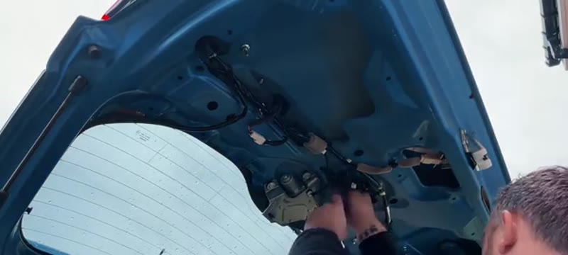 Undoing the 10mm bolts securing the boot mechanism panel on the Suzuki Vitara tailgate