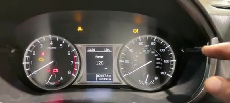 Pressing and holding the right-hand dial button on the Suzuki Vitara instrument cluster