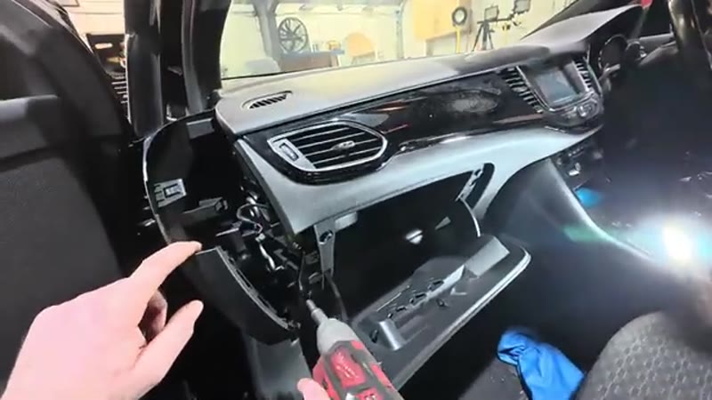 Undoing the 7mm bolts inside the Vauxhall Astra glove box with a ratchet