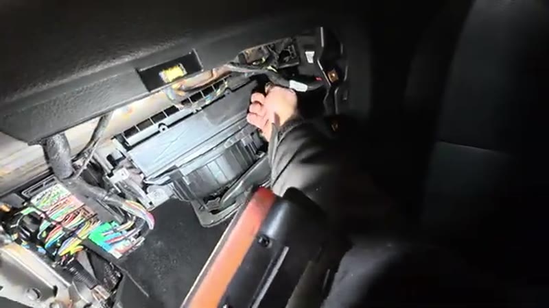 Opening the pollen filter trap door behind the glove box on the Vauxhall Astra