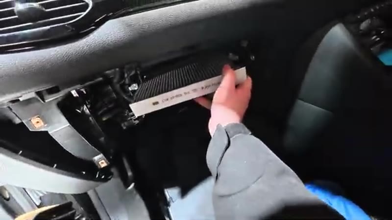 Sliding the new pollen filter into the housing on the Vauxhall Astra with the airflow arrow facing down