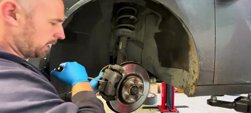 Undoing the caliper bolts with two spanners on the Vauxhall Insignia front brake