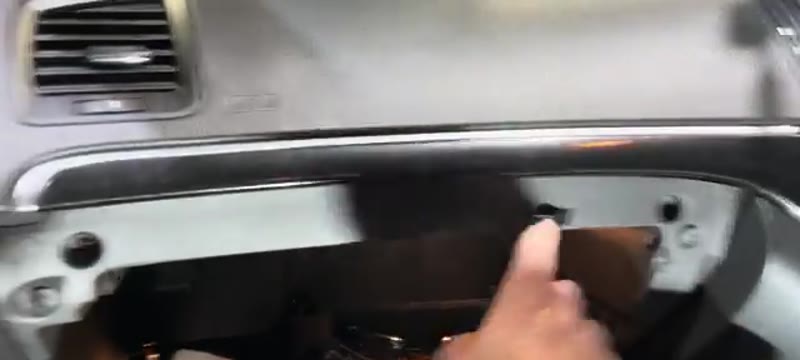 Open glove box on a Vauxhall Insignia with a hand pointing to one of the four 7mm mounting bolts