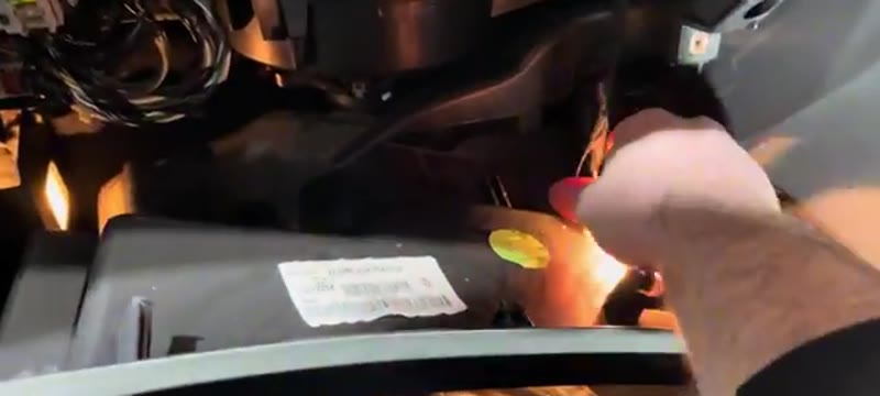 Unplugging the glove box light connector on a Vauxhall Insignia before lowering the glove box