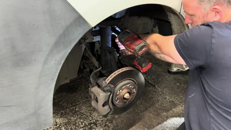 Undoing the anti-roll bar drop link nut on a Vauxhall Vivaro front suspension