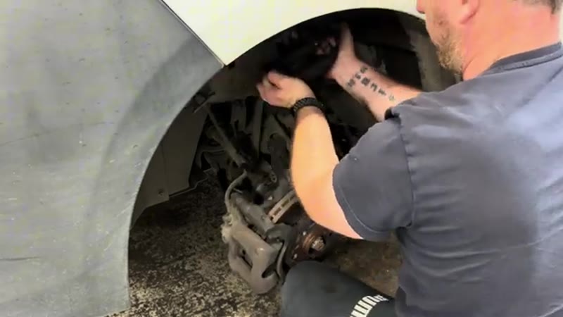Pulling the old shock absorber out of the Vauxhall Vivaro wheel arch