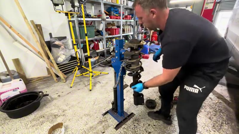 Vauxhall Vivaro shock and spring assembly clamped in a spring compressor for the swap