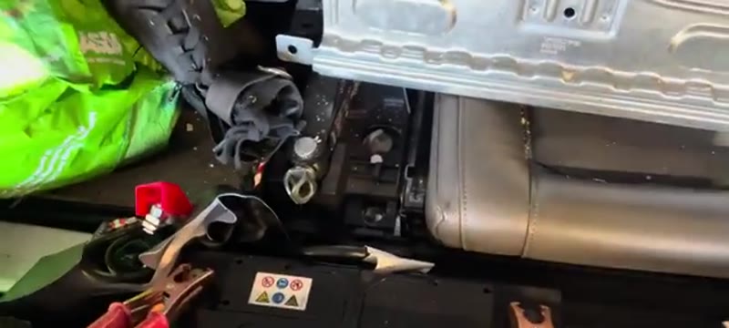 Battery in the boot of a Volvo XC90 with the plastic and metal covers removed ready for disconnection