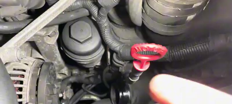 Boost pipe across the top of the Volvo XC90 engine being unclipped and moved aside