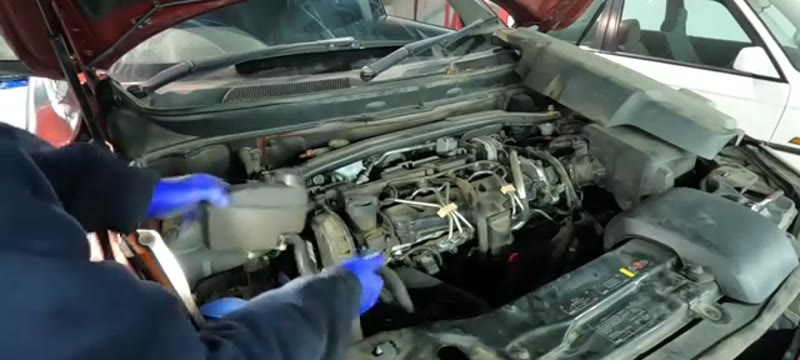 Removing the engine top cover on a Volvo XC90 D5 to access the cambelt area