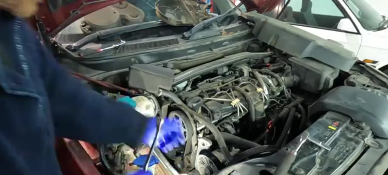Releasing the cambelt tensioner with the 12mm bolt and 6mm Allen key on the Volvo XC90 D5