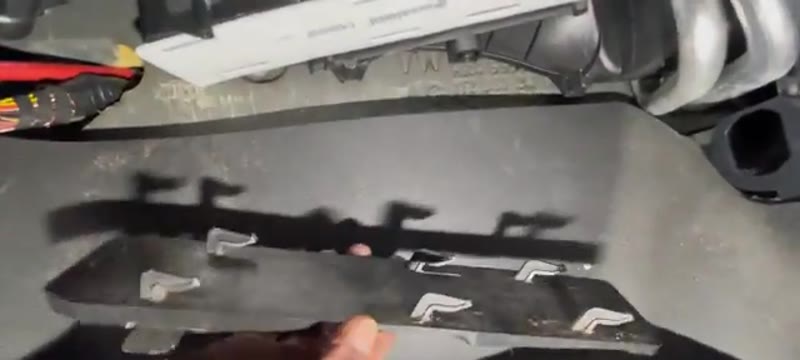Refitting the filter cover with its locating hooks on the VW Caddy