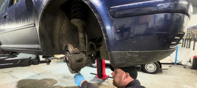 Removing the three 13mm ball joint nuts and retaining plate on the Golf lower arm