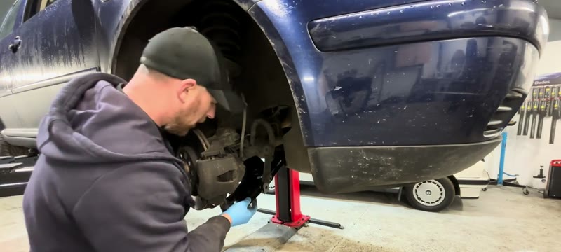 The worn Mk4 Golf lower arm being removed with the failed rear bush visible