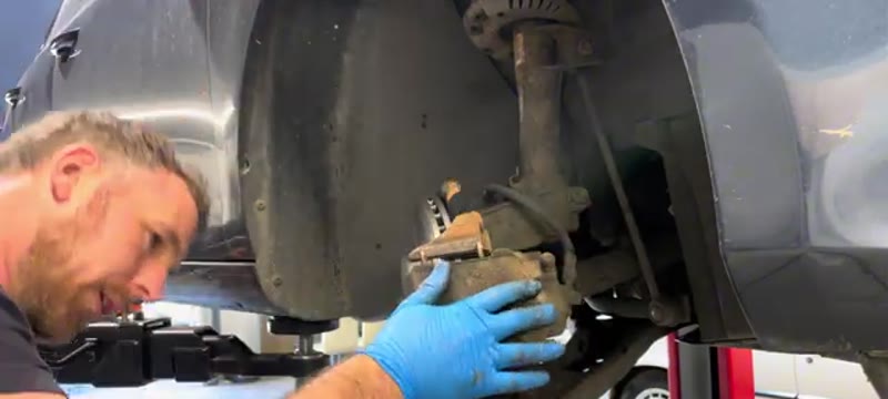 Sliding the caliper back over the new disc and pads