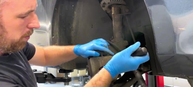 Pushing the caliper piston back with a screwdriver before removing the caliper