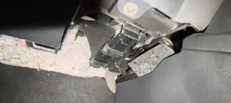 Pollen filter cover with its two sliding tabs under the glove box of a VW Polo