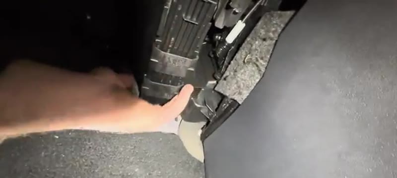 Pulling the pollen filter cover down after sliding the tabs inwards on the VW Polo