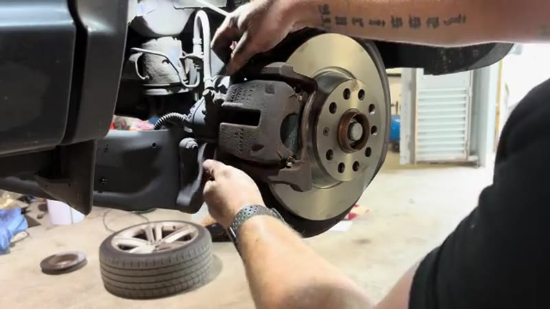 Refitting the caliper over the new pads on the VW Tiguan rear brake