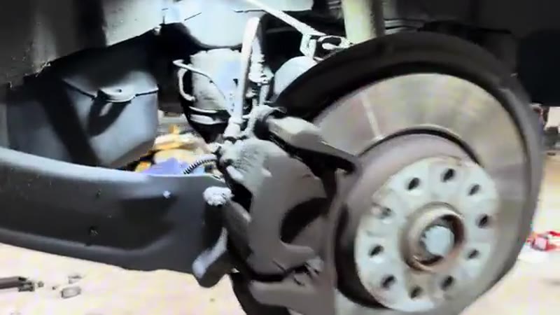 VW Tiguan raised on the lift with the rear wheel removed showing the brake disc and caliper