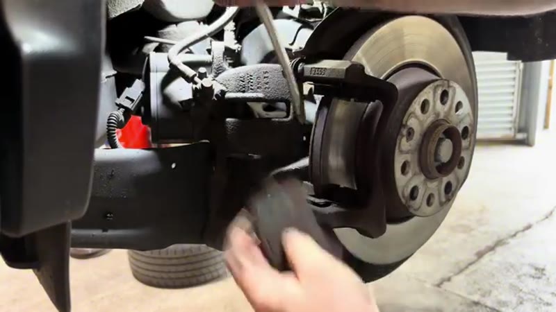 Levering the worn brake pads out of the carrier on the VW Tiguan rear brake