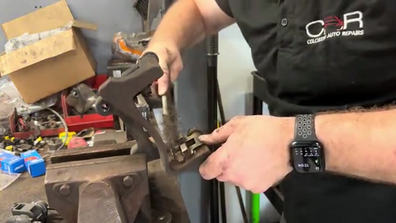 Cleaning the pad channels of the caliper carrier in the vice on the bench