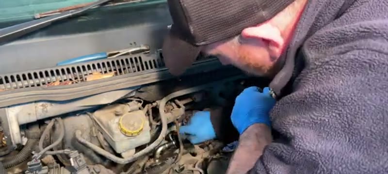 Undoing the two tight 12mm nuts on the flexi pipe at the back of the VW Transporter EGR valve
