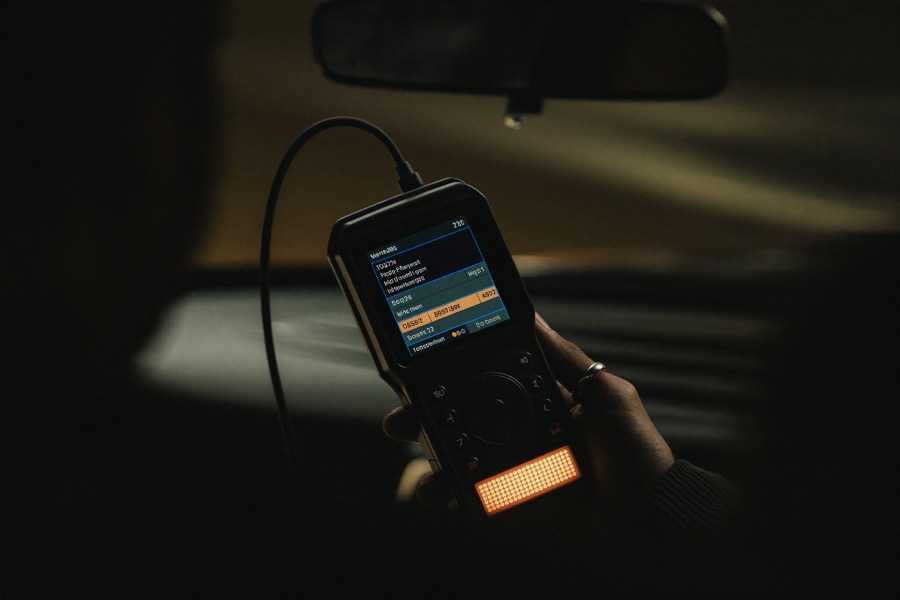 OBD diagnostic scanner plugged into a car showing fault codes