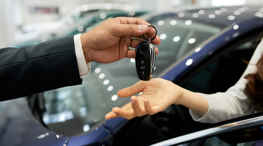Salesperson handing over car keys at a dealership