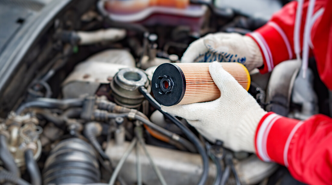 Hands changing the oil filter during a DIY car service