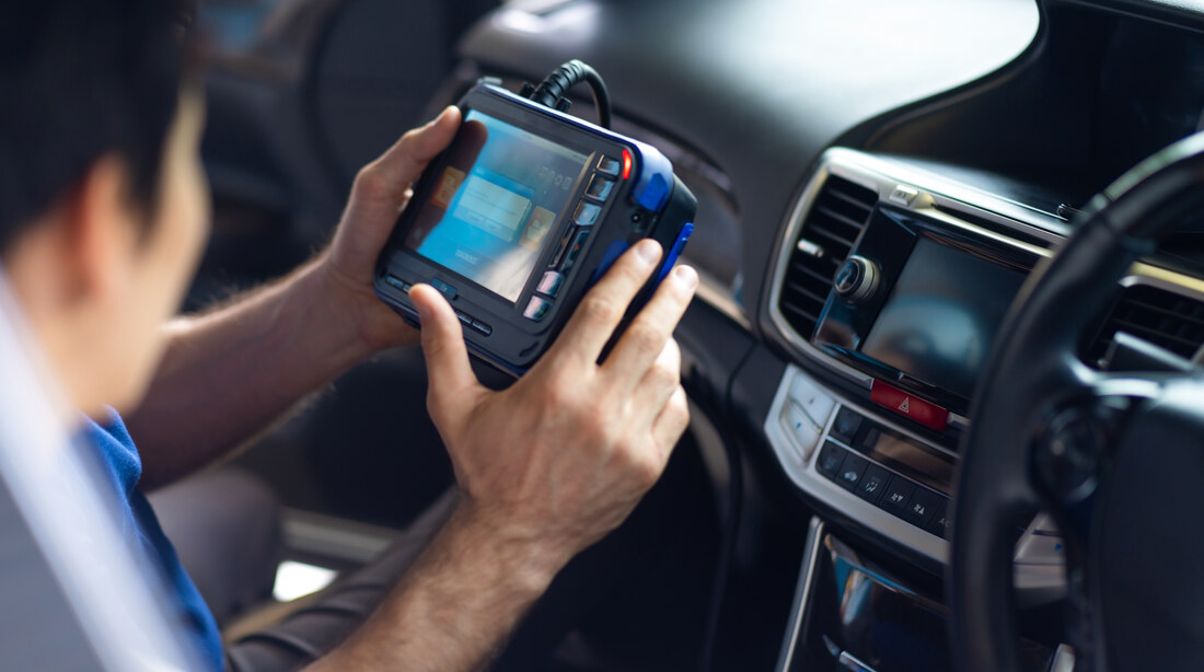 Mechanic running a diagnostic check on a car to read fault codes