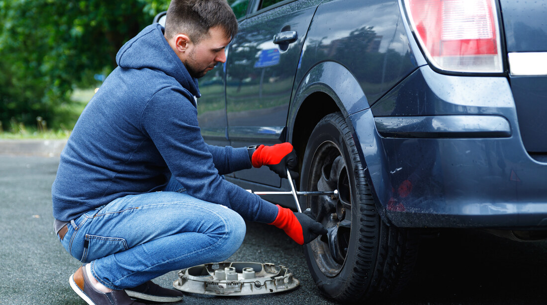 Person changing a wheel at the roadside